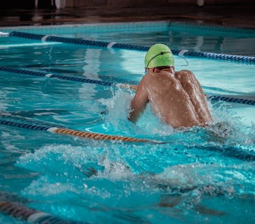 Shirtless Man Swimming on Swimming Pool