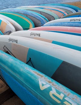 Vibrant surfboards neatly arranged on the beach, ready for water sports enthusiasts.