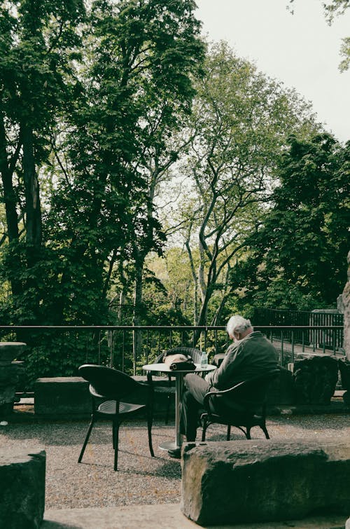 A Man Sitting on a Chair in Outdoor Setting