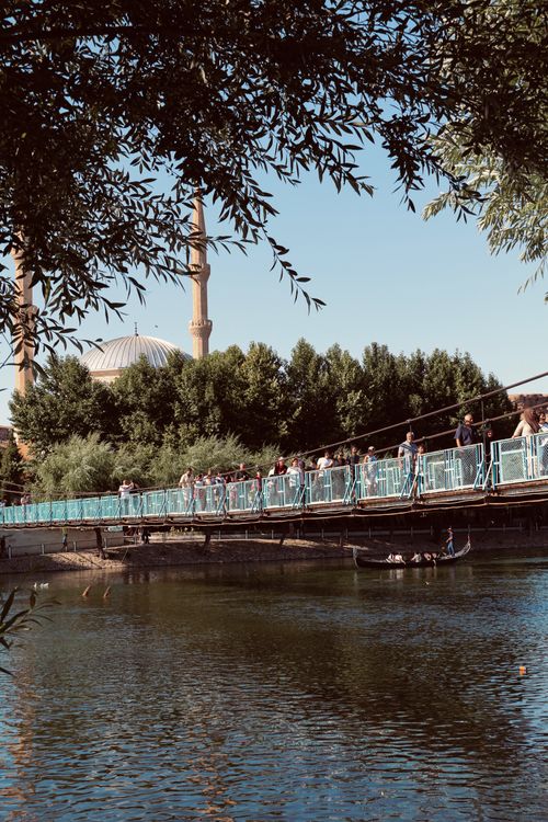 Free View of a footbridge and mosque with minarets in Avanos, Turkey, against a tranquil river. Stock Photo