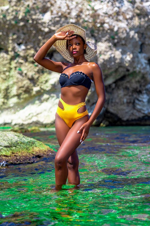 Woman in Yellow Bikini and Black Brassiere Standing on Water