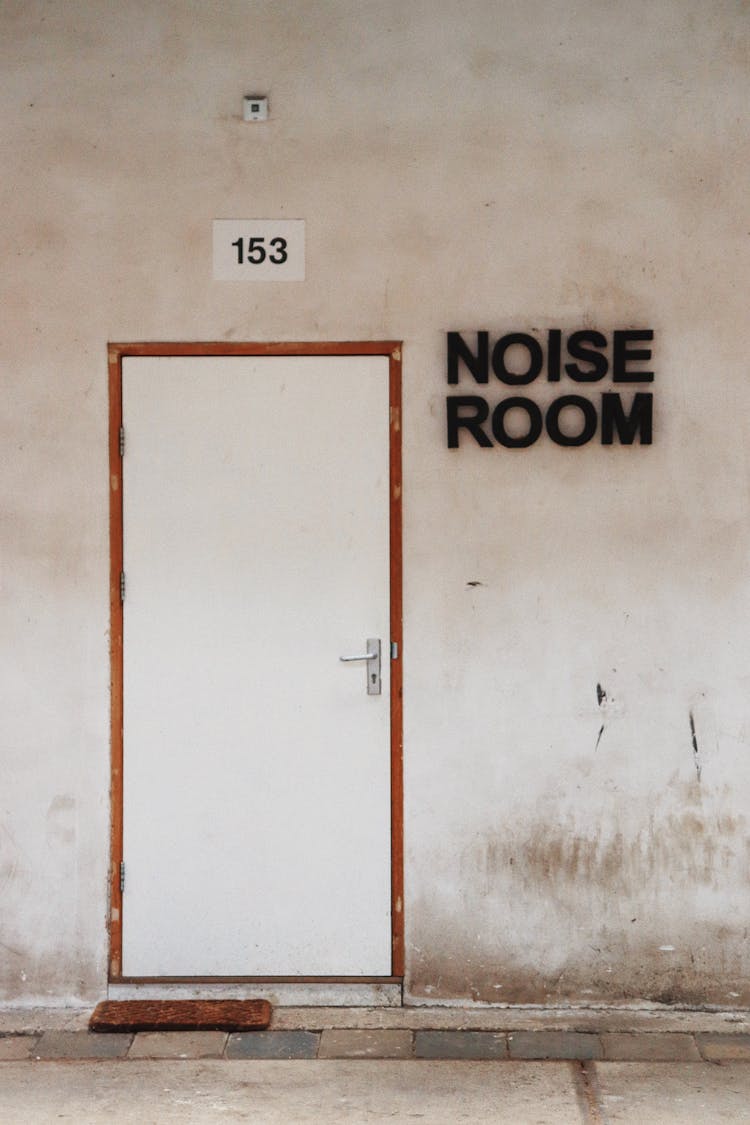 Closed Door And A Sign Saying Noise Room 