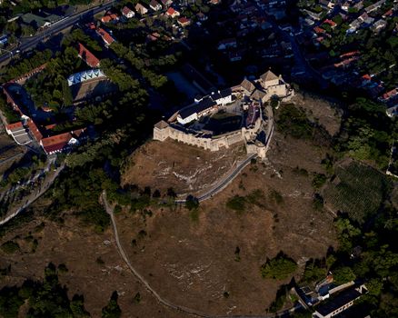 Stunning aerial view of historic Sümeg Castle surrounded by lush landscape in Hungary.