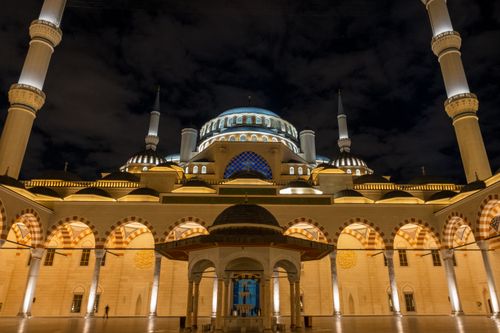 Free Stunning view of a mosque with grand arches and minarets, beautifully lit at night. Stock Photo