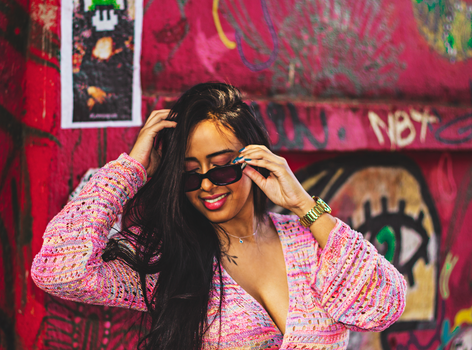 Fashionable woman in sunglasses by vibrant graffiti wall in São Paulo, Brazil.