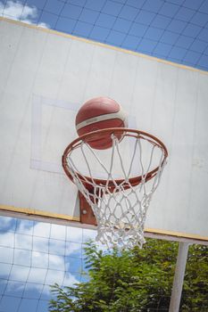 Basketball caught midair close to a hoop outdoors in Popayán, Colombia.