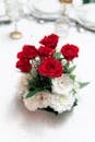 桌子上摆放着优雅的红玫瑰和白花花束，非常适合婚礼