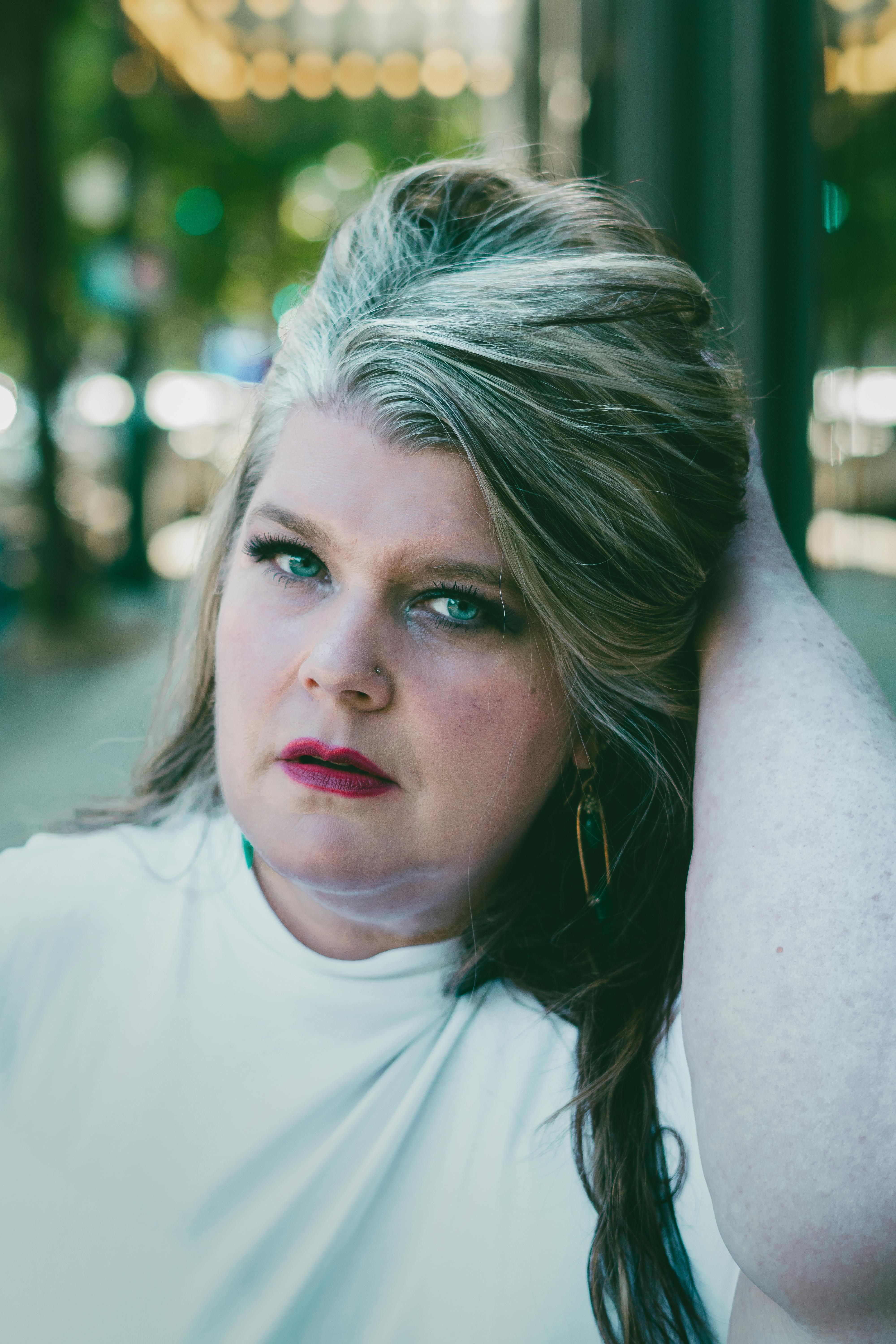 Portrait of a confident plus size woman with stylish hair posing outdoors.