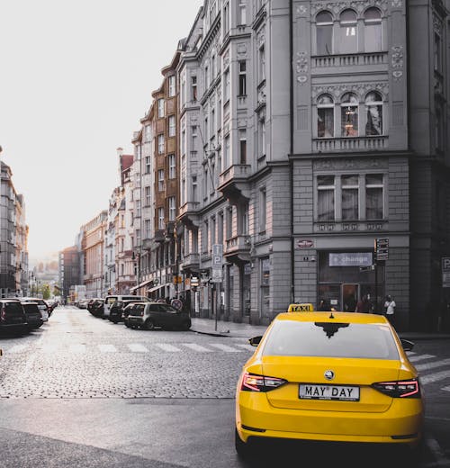 免費 黃色出租車車輛附近灰色混凝土建築 圖庫相片
