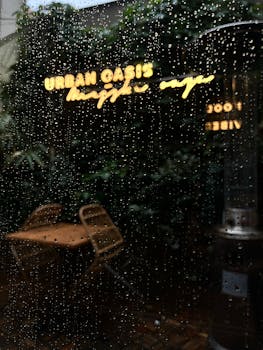 Raindrops on café window, neon sign reflection reading 'Urban Oasis.'