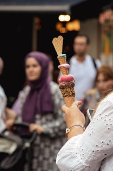 A vibrant ice cream cone is held up amidst a busy street in Istanbul, offering a taste of local culture.