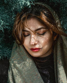 Serene portrait of a woman with closed eyes, draped in warm clothing.