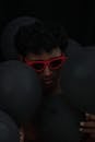Man in Sunglasses with Black Balloons