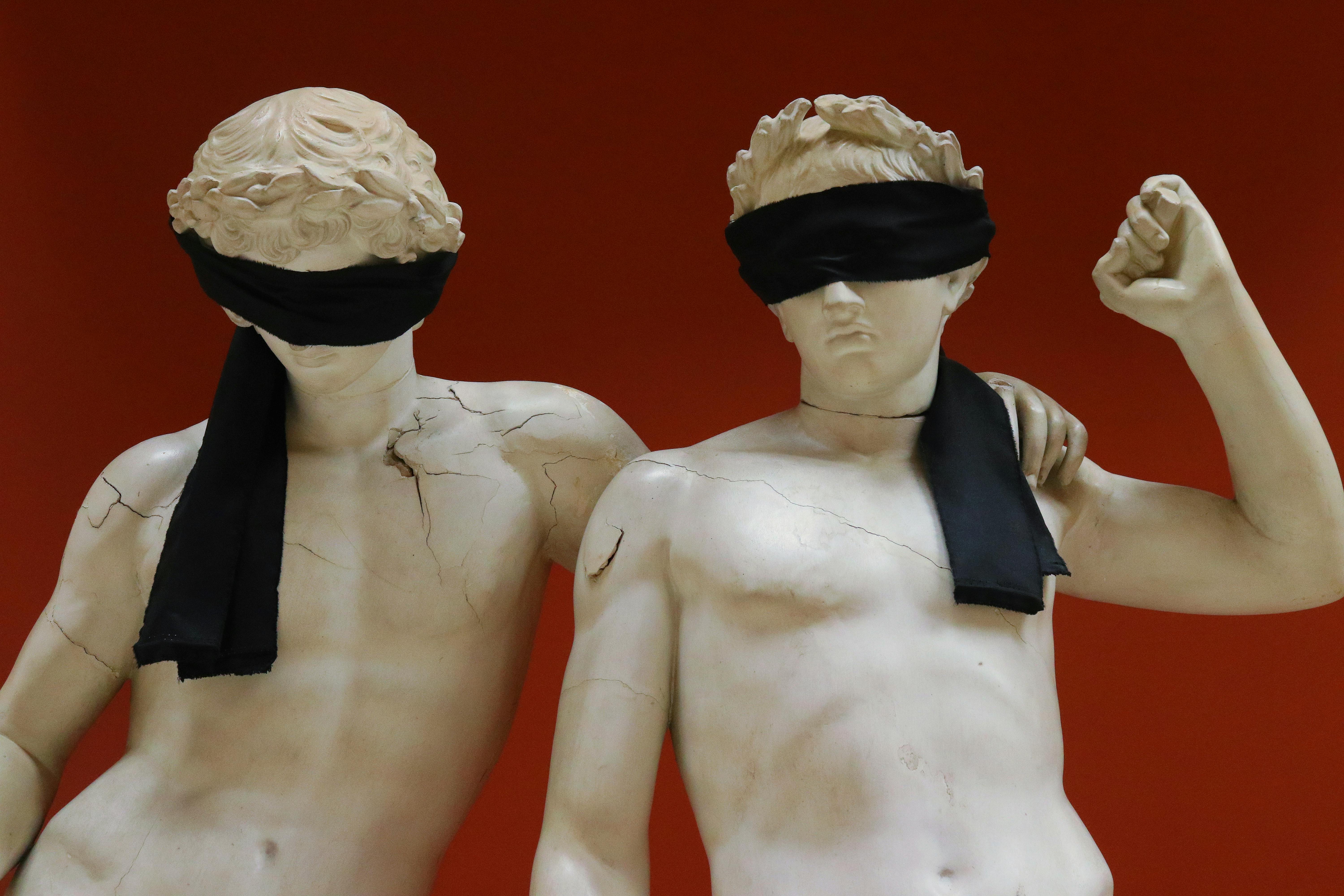 statues blindfolded with black textile