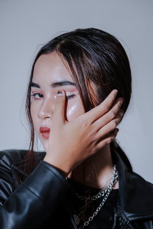 Woman in Black Leather Jacket Covering Her Eye