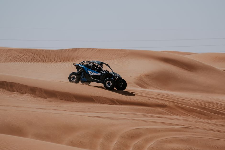 A thrilling off-road aventure with a dune buggy speeding through desert sand dunes.