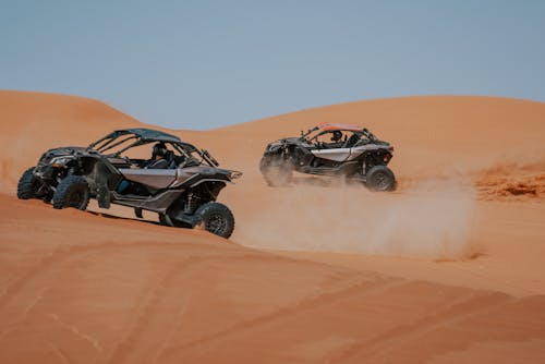 Dune Buggies on Sand Dunes Under a Clear Blue Sky