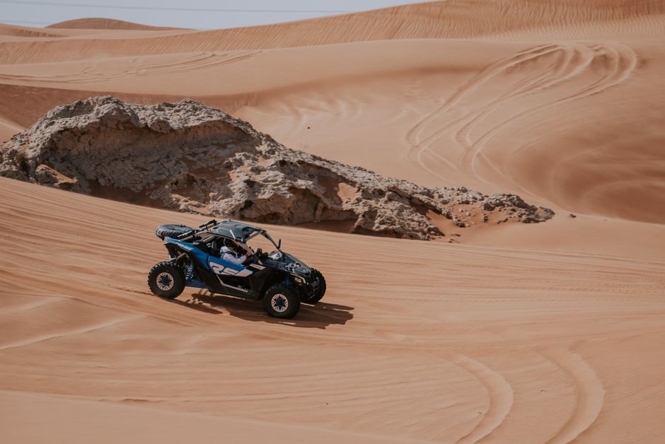 Exciting ATV ride on rugged desert sand dunes, showcasing dynamic landscapes and adventure.