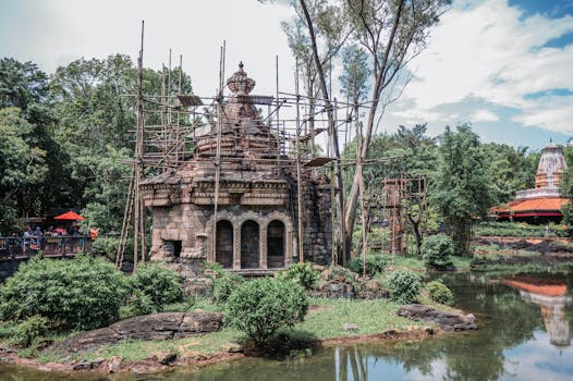 Scenic view of an ancient-looking temple surrounded by lush greenery in a theme park setting.