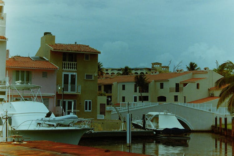 Yachts Docked On A Marina Near Concrete Houses