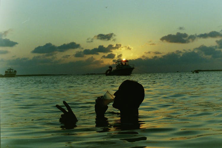 Silhouette Of Person Drinking On The Beach