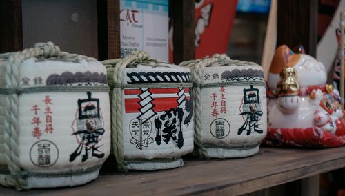Free Outdoor display of traditional Japanese sake barrels with a ceramic lucky cat figurine. Stock Photo