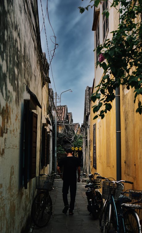 Man Walking in a Narrow Alley between Traditional Buildings 