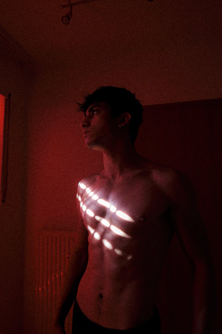 A Man Standing Shirtless In A Room