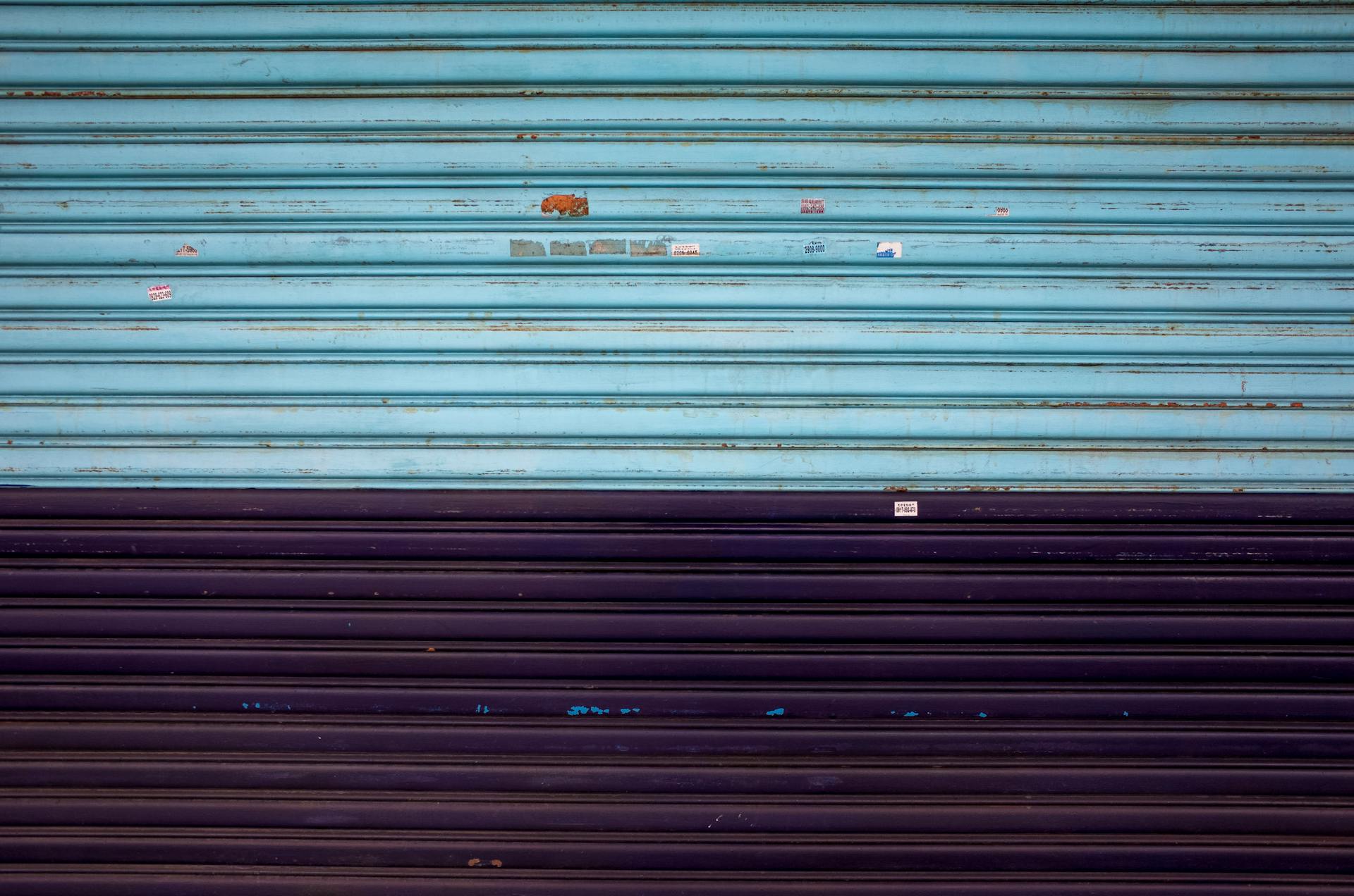 High-quality close-up of a corrugated metal shutter with a turquoise and black gradient, ideal for urban-themed projects.