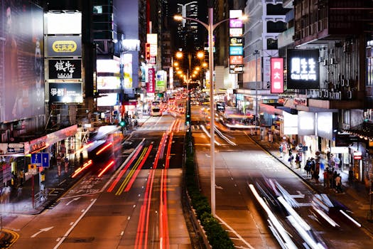 Captivating long exposure of bustling Hong Kong street at night, showcasing dynamic city lights and urban life.