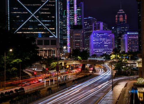 Free Vibrant night view of Hong Kong cityscape with light trails and illuminated skyscrapers. Stock Photo