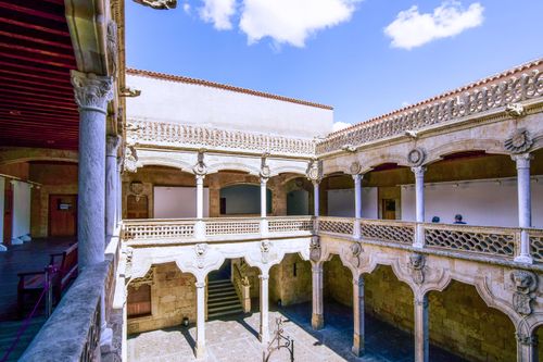 Free Beautiful Renaissance courtyard featuring classic stone columns and arches under a bright sky. Stock Photo