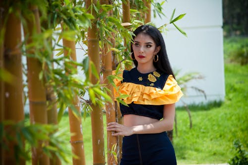 Woman Wearing Black And Yellow Crop Top Holding Bamboo