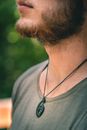 Man Wearing Black Necklace and Gray Shirt