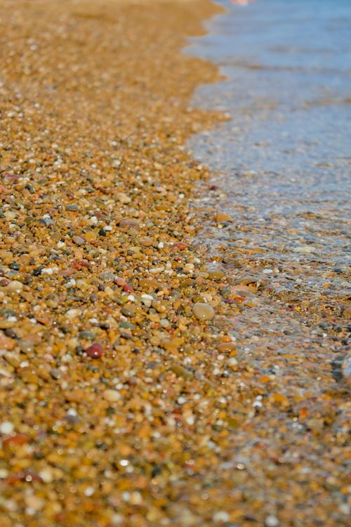 Free Macro shot of a pebble beach in Turkey with shallow sea water edging the shore. Stock Photo