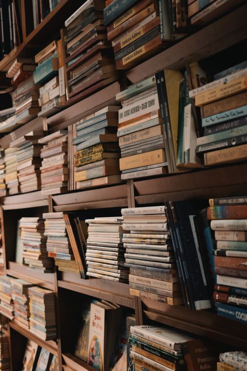 Free A wooden bookshelf packed with various books, perfect for education and learning themes. Stock Photo