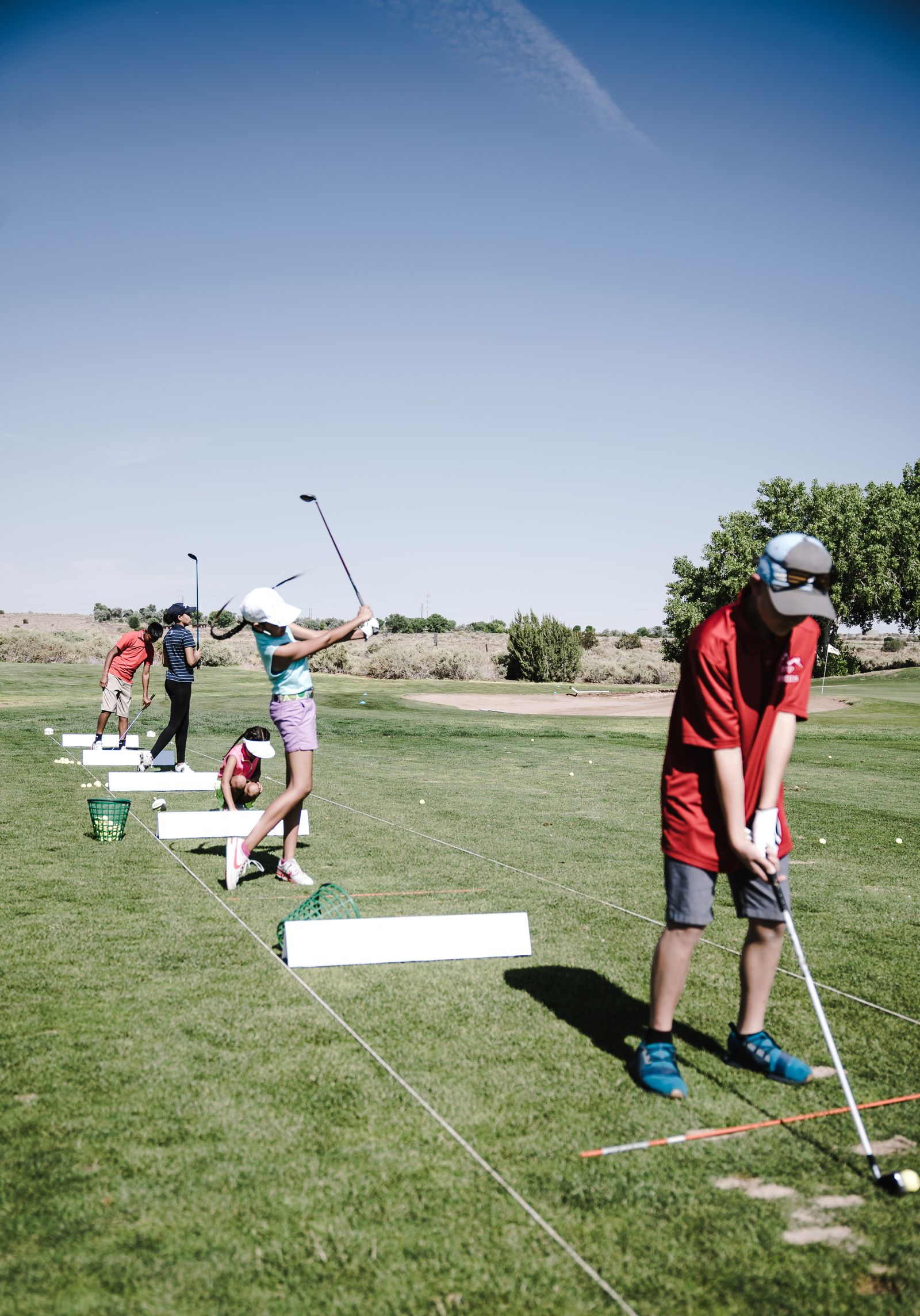 Golfer swinging a club on a sunny green course