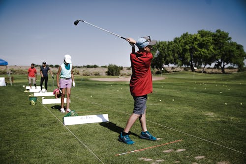 Person Swinging Golf Club on Field