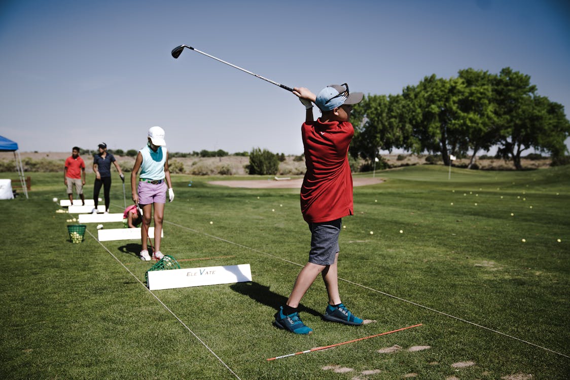 Free Person Swinging Golf Club on Field Stock Photo