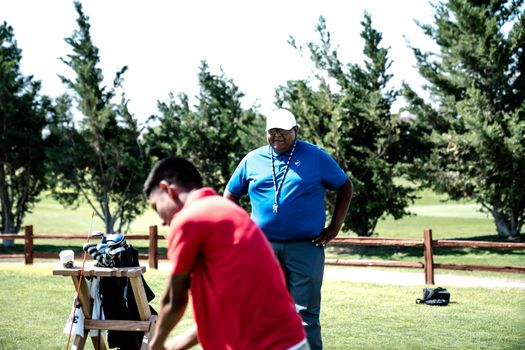 Man in Red Polo Shirt Standing Near Man in Blue Top Holding His Waist