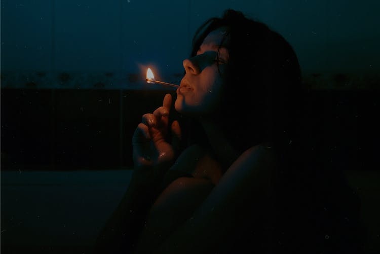 Woman Smoking In Dark In Bathroom