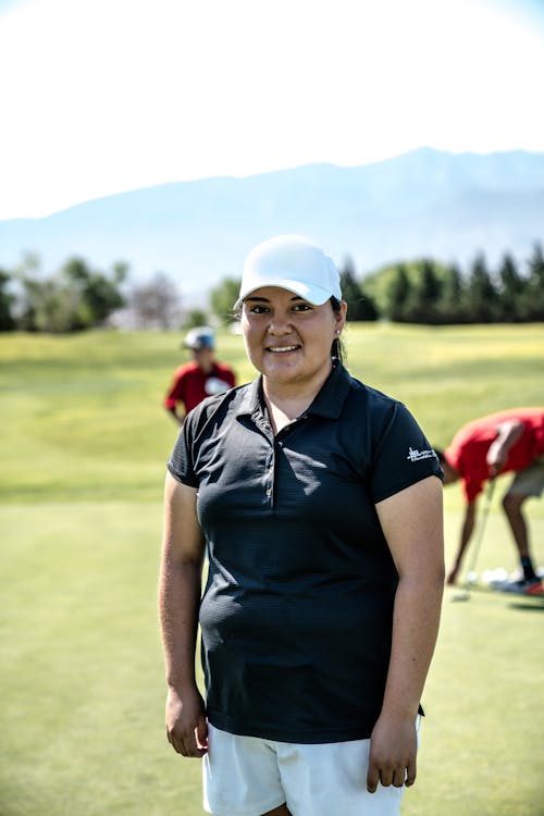 Smiling Woman Standing on Golf Course