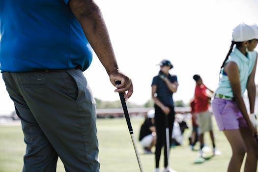 Golfers practicing swings on a bright day at the range, enjoying outdoor leisure activity.
