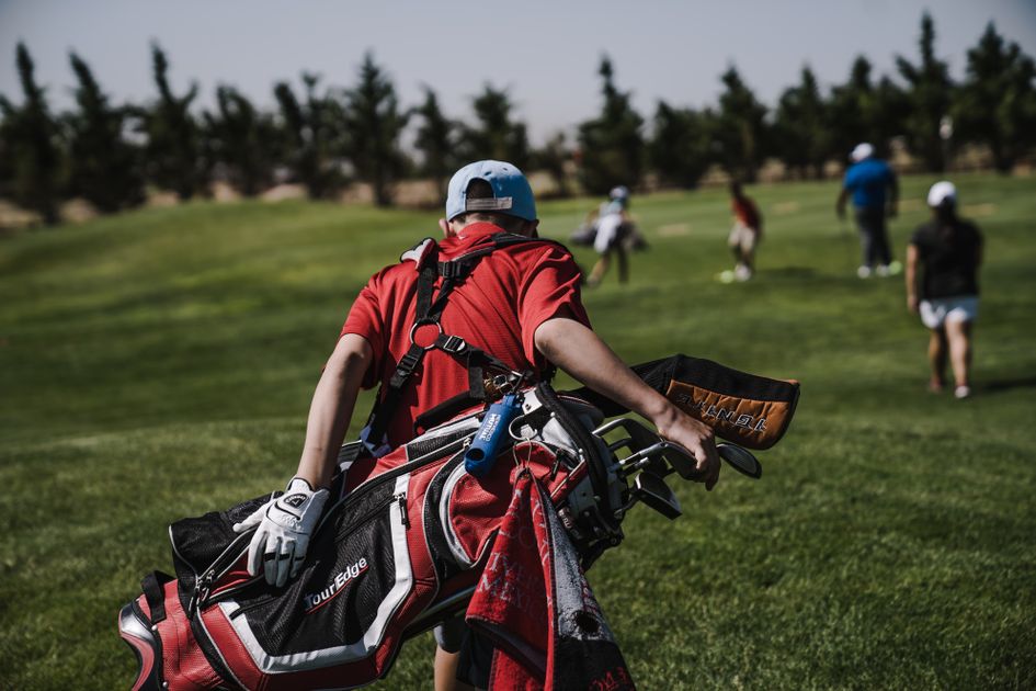 Golf instructor reviewing student progress on a tablet at the driving range