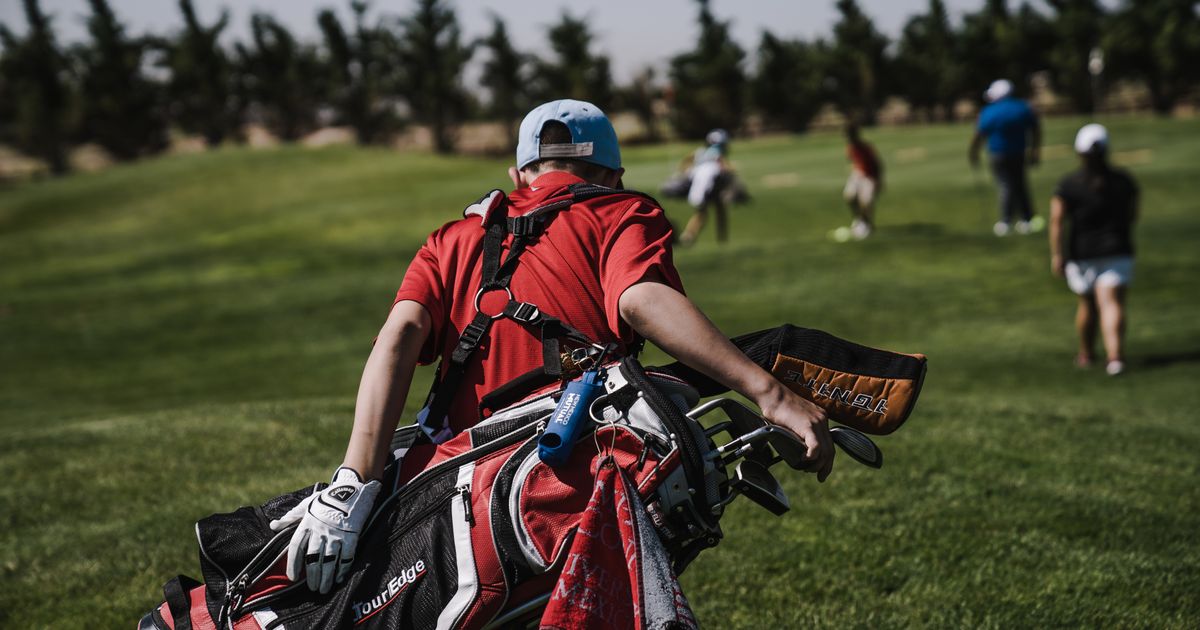 Golf instructor reviewing student progress on a tablet at the driving range