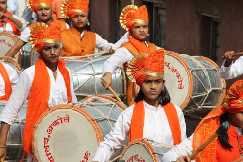 People Wearing Traditional Dress Playing Drum