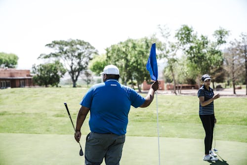 拿著藍色小旗的人拿著高爾夫球司機