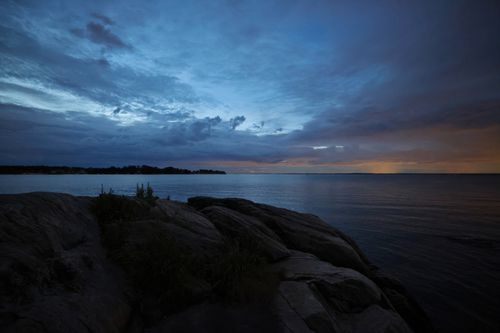 Free Peaceful twilight over rocky shore and calm sea in Stamford, CT. Stock Photo