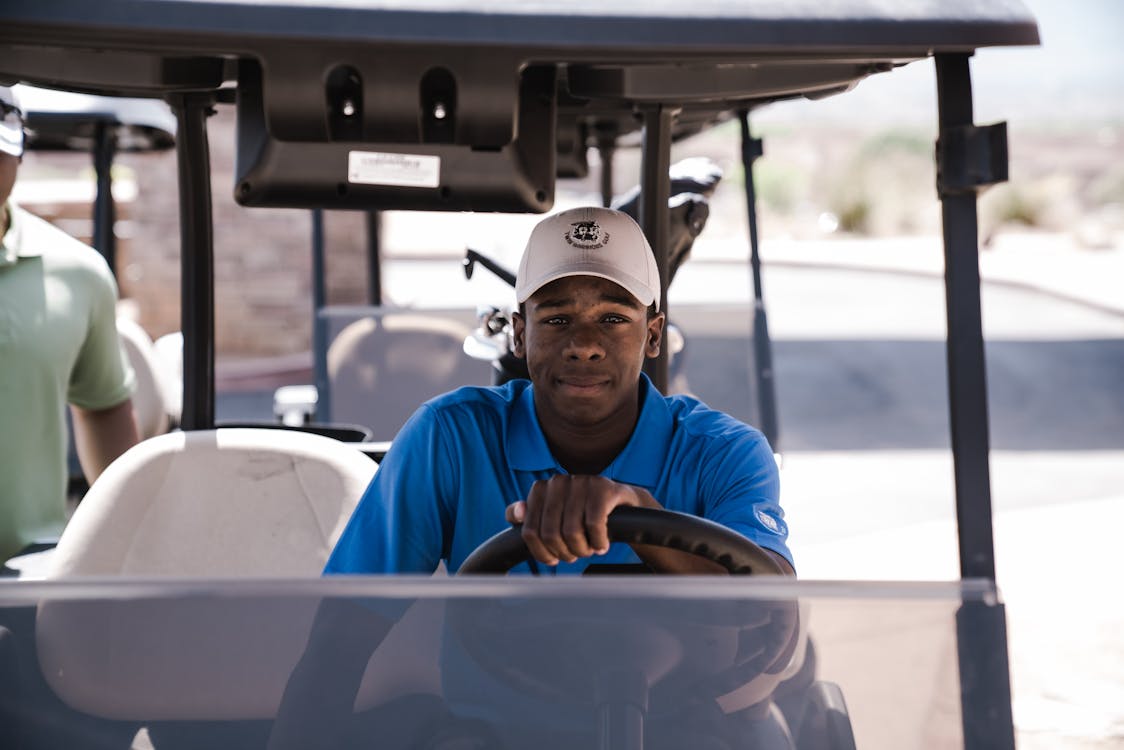 免费 男子坐在高尔夫球车上 素材图片