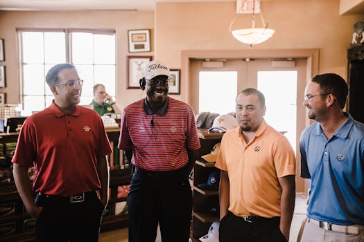 Group of four men in colorful golf attire smiling together indoors.